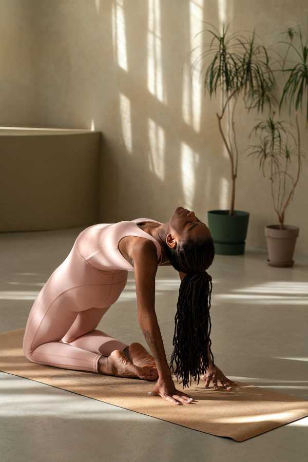 Adult sitting calmly on a yoga mat outdoors